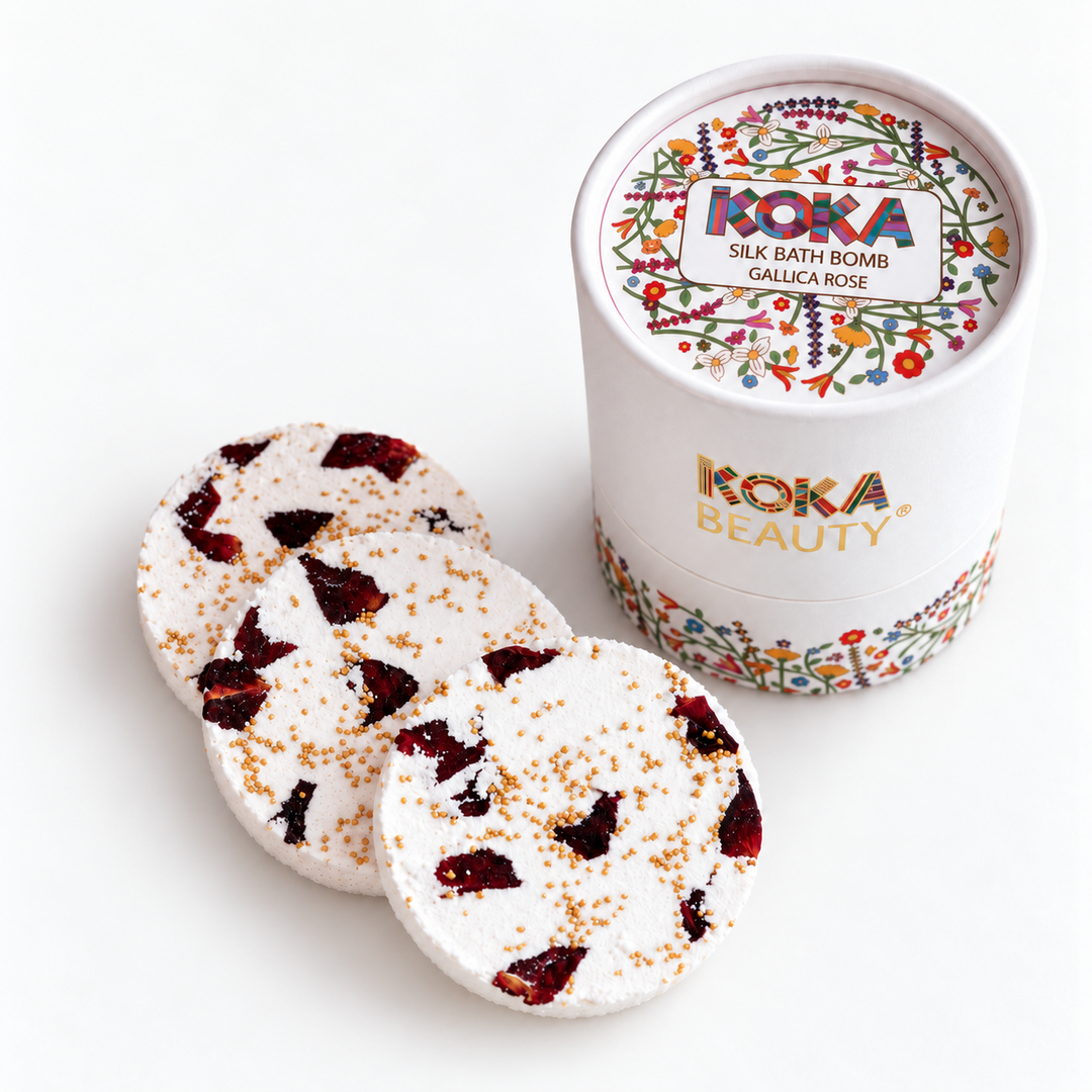 Three Koka Beauty Gallica Rose silk bath bombs with red petals beside the floral presentation jar