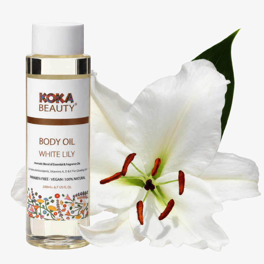 Koka Beauty White Lily Body Oil bottle beside an open white lily flower on white