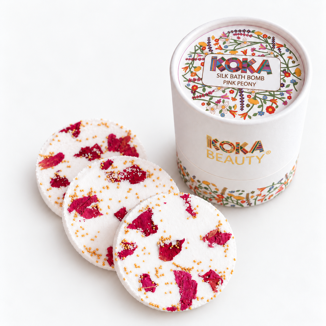 Three Koka Beauty Pink Peony silk bath bombs with rose petals beside the floral presentation jar